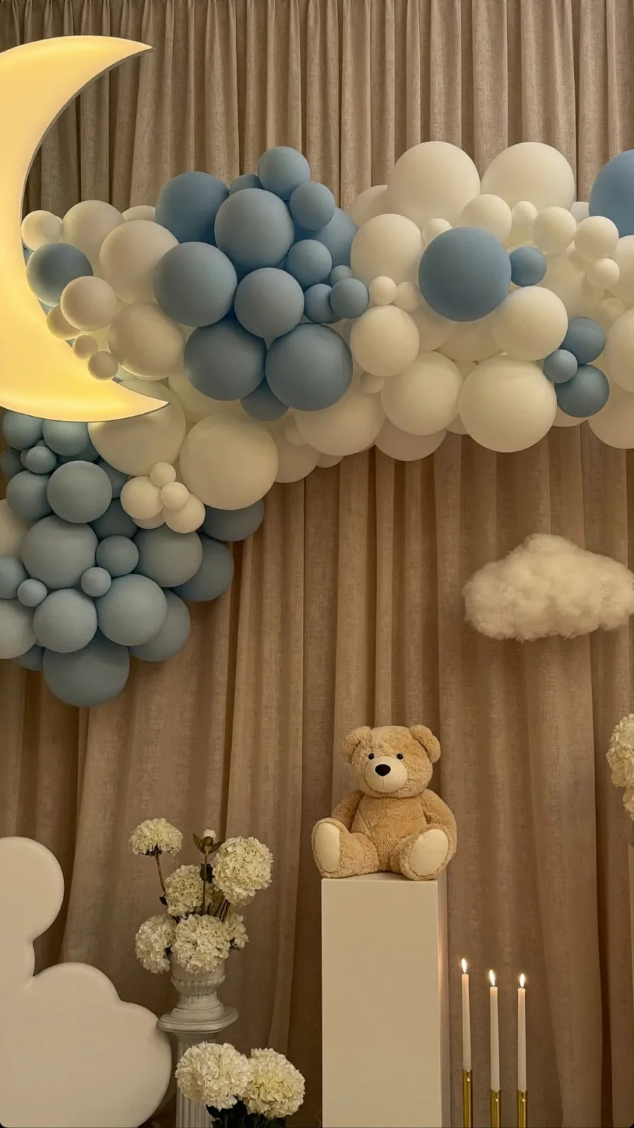 Rincón de baby shower en tonos azules con globos y nubes